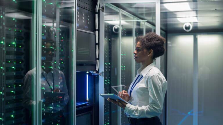 Female technician works on a tablet in a data center