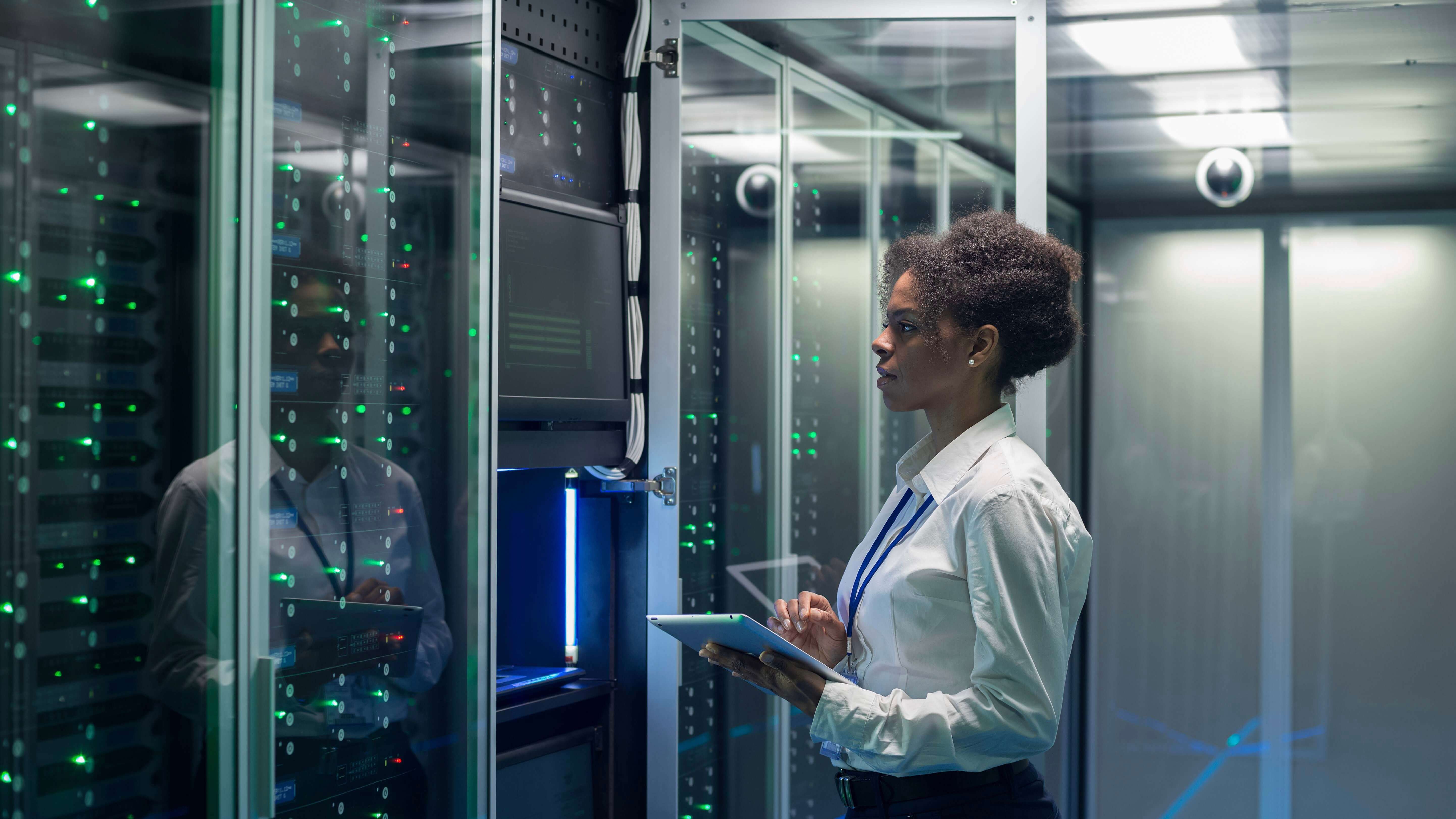 Female technician works on a tablet in a data center